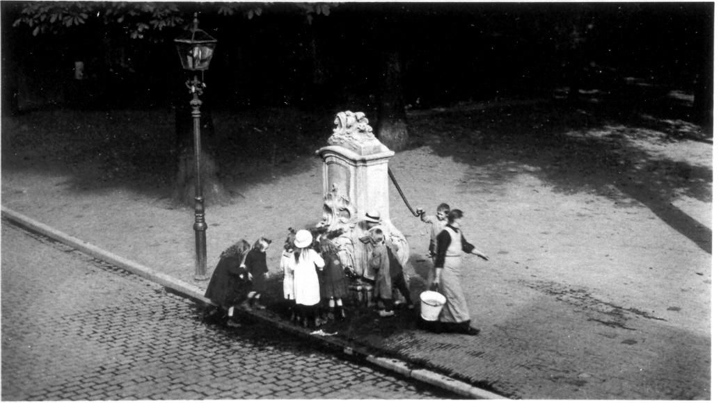 Foto uit het jaar 1920 - mensen staan bij stadspomp Luttekestraat